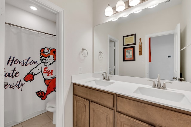 bathroom with tile patterned floors, vanity, toilet, and walk in shower