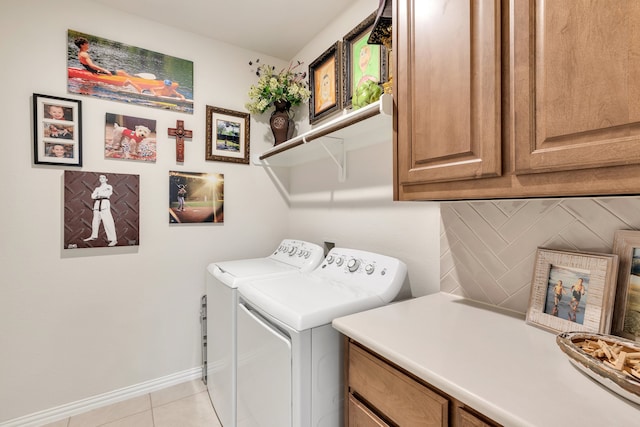 laundry room featuring cabinets, light tile patterned floors, and washing machine and clothes dryer