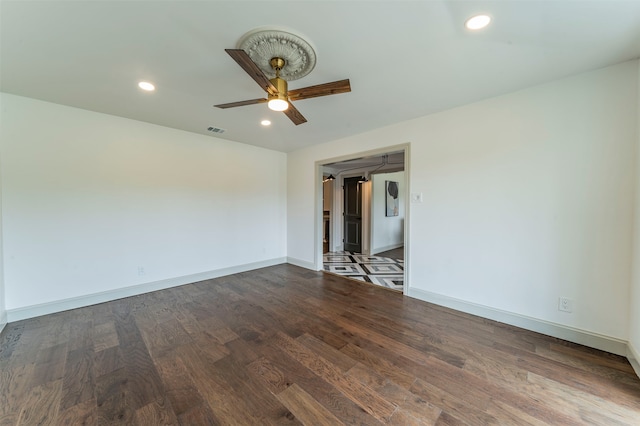 spare room featuring dark hardwood / wood-style flooring and ceiling fan