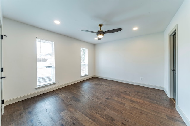 spare room with ceiling fan, a wealth of natural light, and dark hardwood / wood-style floors