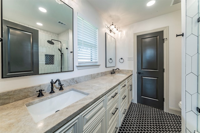 bathroom featuring an enclosed shower, toilet, and double sink vanity