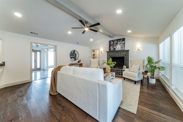 living room featuring lofted ceiling with beams, ceiling fan, a brick fireplace, and dark wood-type flooring