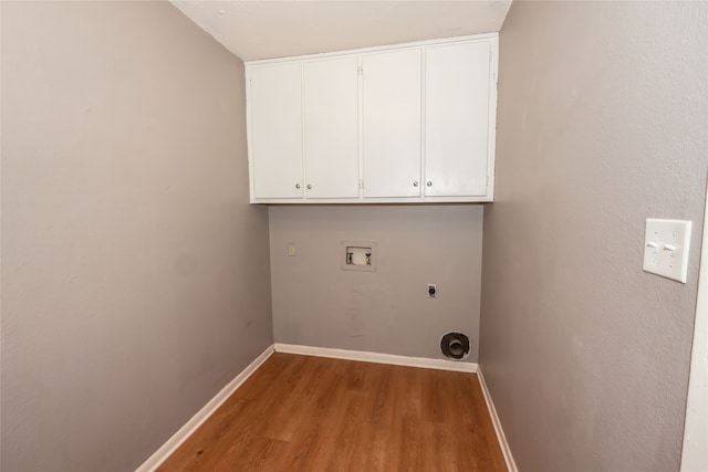 clothes washing area with cabinets, hookup for a washing machine, wood-type flooring, and electric dryer hookup