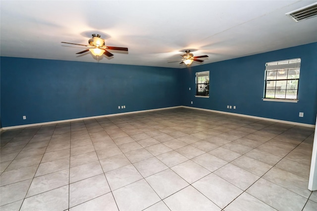 spare room featuring baseboards, visible vents, and a ceiling fan