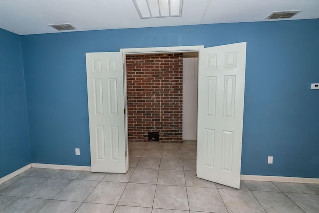 spare room featuring light tile patterned floors and visible vents