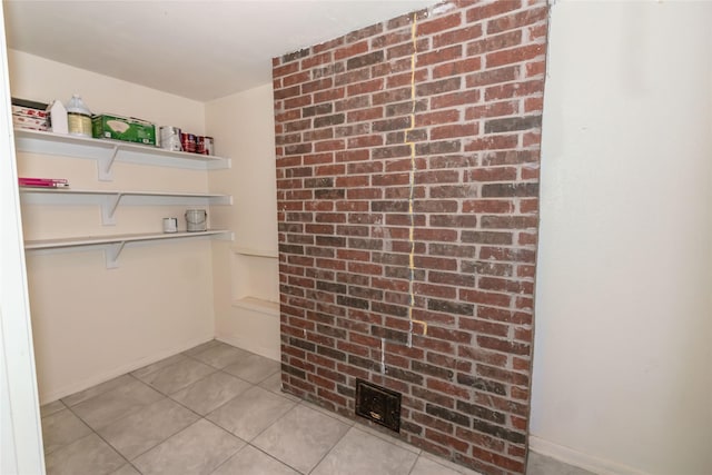 walk in closet with light tile patterned floors