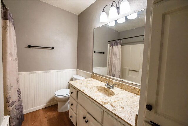 bathroom with hardwood / wood-style flooring, toilet, and vanity