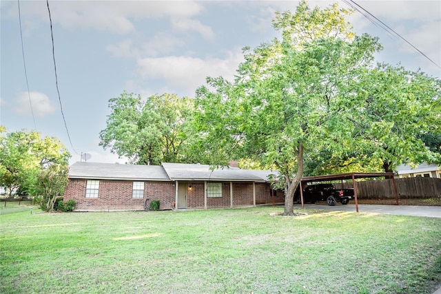 ranch-style home with a front lawn, an attached carport, fence, and brick siding