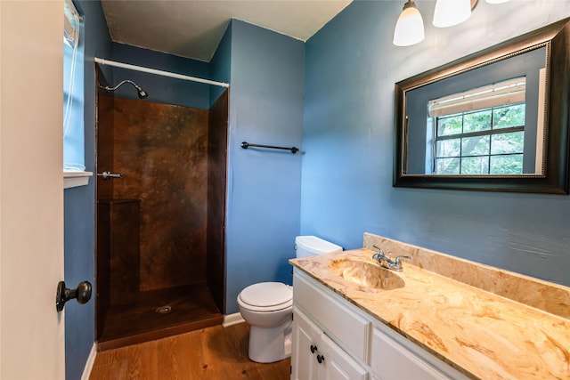 full bathroom featuring toilet, a stall shower, vanity, wood finished floors, and baseboards