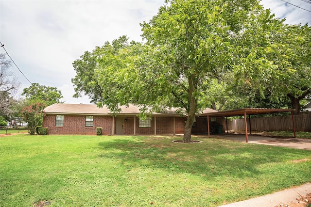 view of front of property featuring a carport, brick siding, fence, and a front lawn