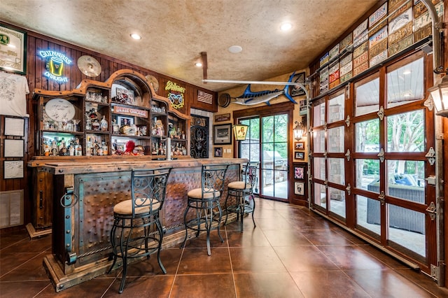 bar with a dry bar, recessed lighting, visible vents, and dark tile patterned flooring