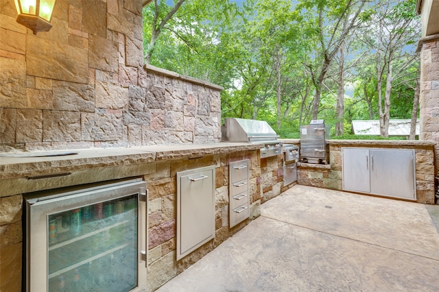 view of patio / terrace with wine cooler, area for grilling, and a grill