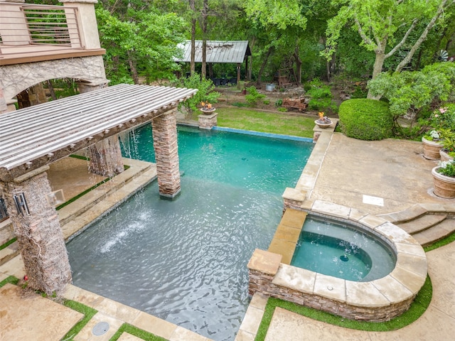 view of swimming pool with pool water feature and an in ground hot tub