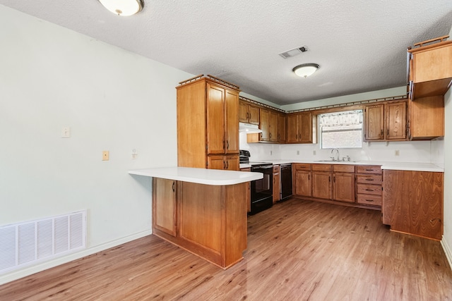 kitchen with kitchen peninsula, black appliances, a textured ceiling, sink, and light wood-type flooring