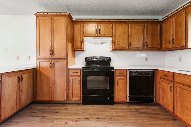 kitchen with hardwood / wood-style flooring, extractor fan, black appliances, and a textured ceiling