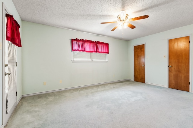 unfurnished bedroom with a textured ceiling, ceiling fan, and carpet