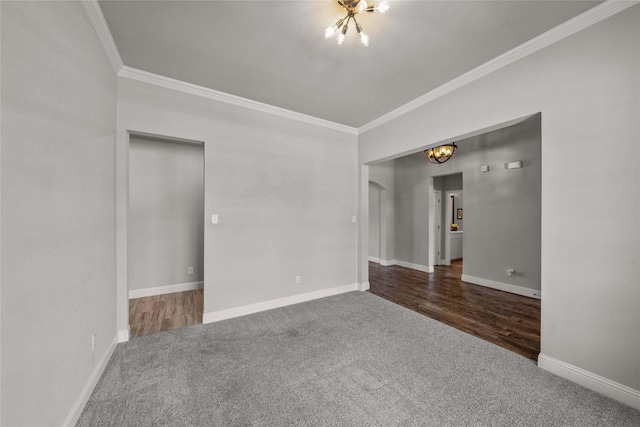 carpeted spare room with ornamental molding and a notable chandelier