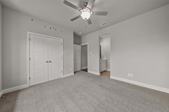 unfurnished bedroom with connected bathroom, a closet, ceiling fan, and carpet