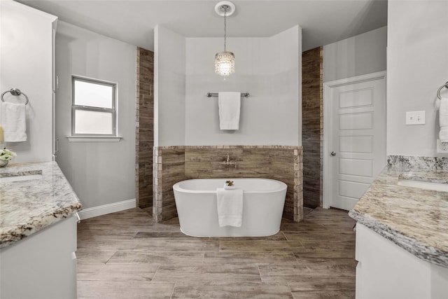 bathroom featuring vanity, tile walls, and a tub