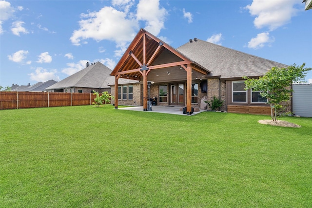 rear view of property featuring a patio area and a lawn