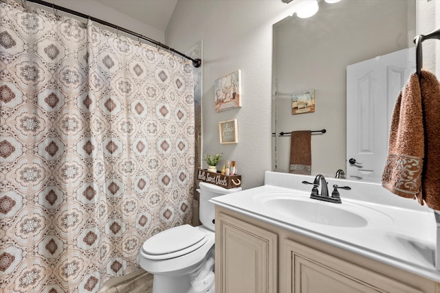 bathroom with vanity, toilet, and curtained shower