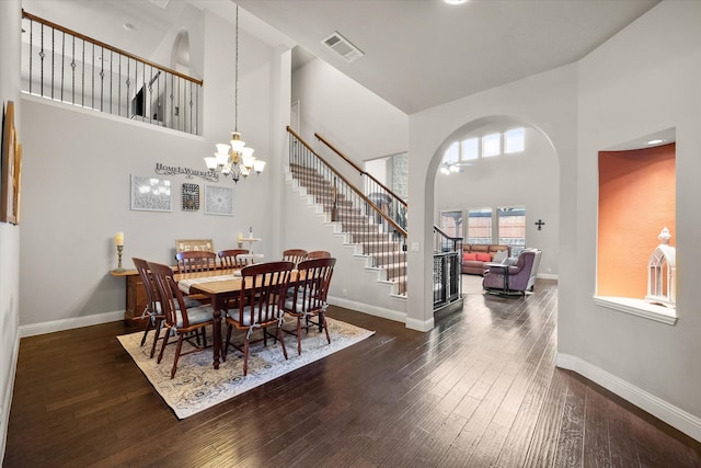 dining room with an inviting chandelier, high vaulted ceiling, and dark hardwood / wood-style flooring