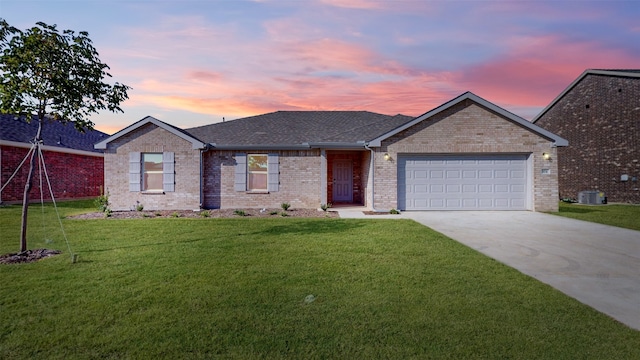 ranch-style house with a garage, cooling unit, and a yard