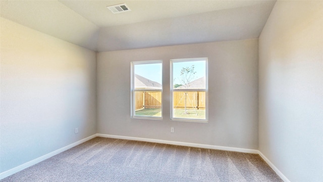 carpeted empty room with lofted ceiling