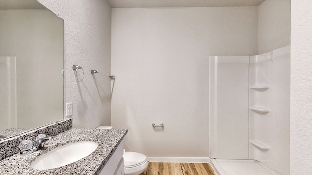 bathroom featuring vanity, a shower, toilet, and wood-type flooring