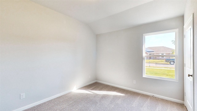 spare room featuring lofted ceiling and carpet