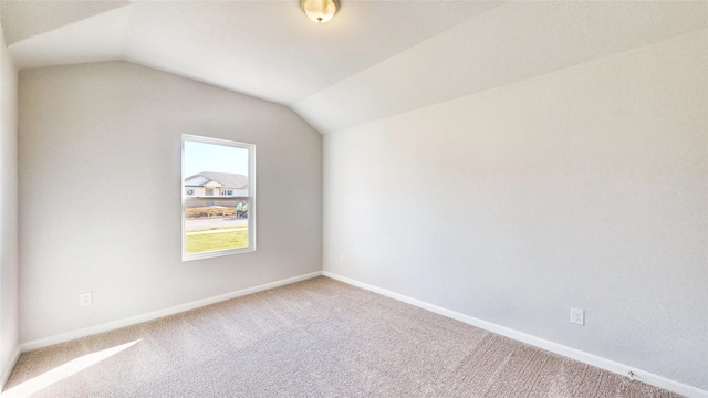 empty room with vaulted ceiling and carpet