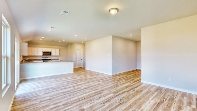 unfurnished living room featuring light hardwood / wood-style flooring and sink