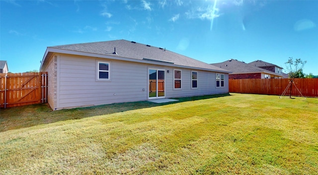 rear view of house featuring a yard