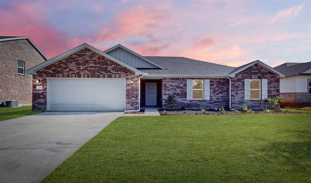 view of front of house with a garage, a lawn, and central AC