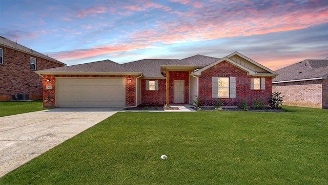 ranch-style house featuring a yard, cooling unit, and a garage