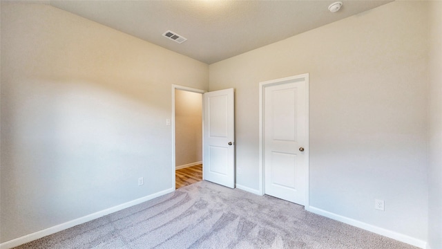 unfurnished bedroom featuring light carpet