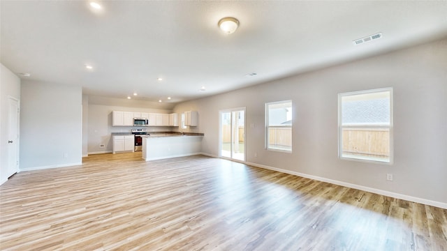 unfurnished living room with plenty of natural light and light hardwood / wood-style flooring