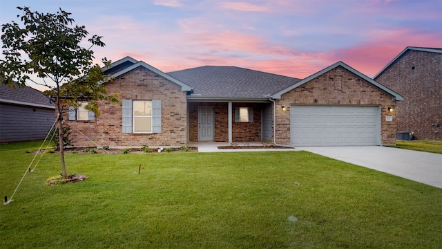 single story home with a garage and a yard