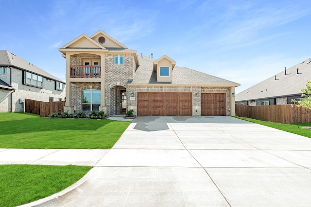 view of front of home with brick siding, concrete driveway, a front yard, fence, and a balcony