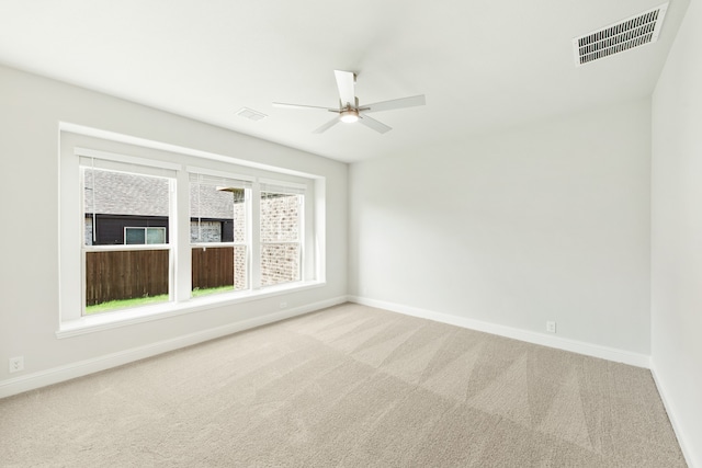 empty room featuring carpet, visible vents, and baseboards