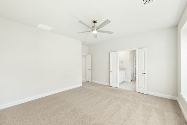 spare room featuring light carpet, baseboards, visible vents, and a ceiling fan