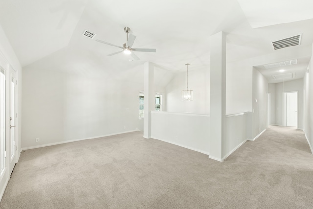 carpeted empty room with attic access, visible vents, vaulted ceiling, and baseboards