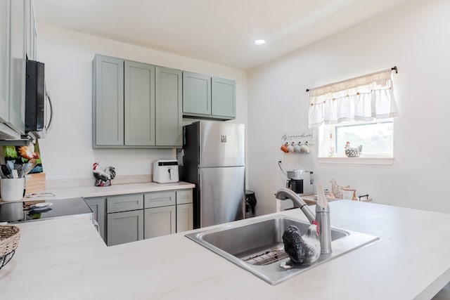 kitchen with stainless steel refrigerator, sink, range, and kitchen peninsula