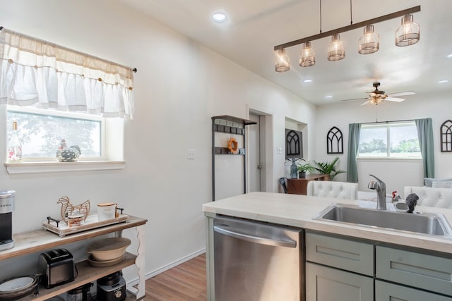 kitchen with ceiling fan, light hardwood / wood-style floors, stainless steel dishwasher, hanging light fixtures, and sink