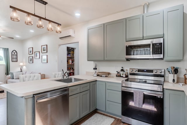 kitchen featuring appliances with stainless steel finishes, sink, kitchen peninsula, and an AC wall unit