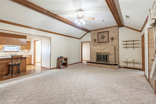 unfurnished living room featuring a textured ceiling, vaulted ceiling with beams, and light carpet