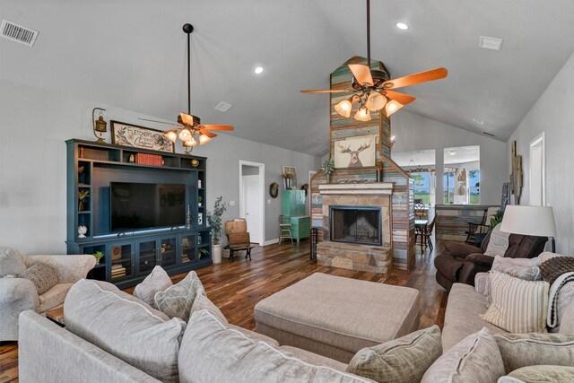 living room with high vaulted ceiling, dark hardwood / wood-style flooring, ceiling fan, and a stone fireplace