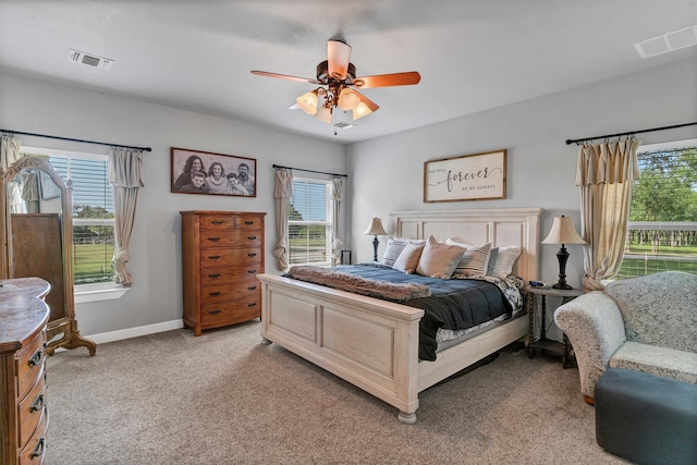 carpeted bedroom with ceiling fan and multiple windows