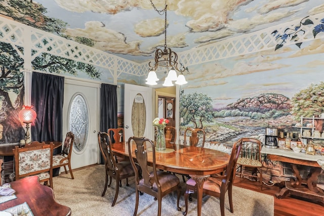 dining area with hardwood / wood-style flooring and an inviting chandelier