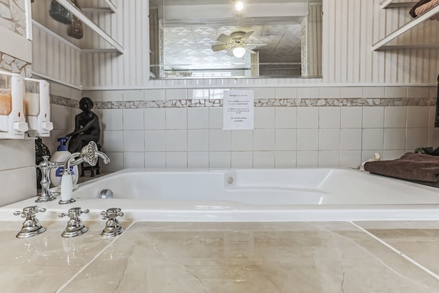 bathroom with tiled tub and ceiling fan